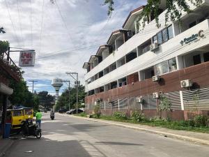 a person riding a motorcycle down a street next to a building at Affordable Family Loft near SM Uptown Cagayan de Oro in Cagayan de Oro