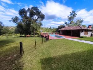 a yard with a swimming pool and a building at Sítio ou chácara in Gravataí