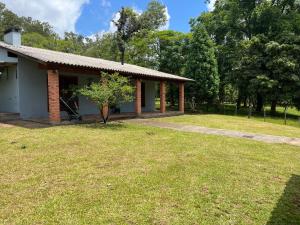 a house with a grass yard in front of it at Sítio ou chácara in Gravataí