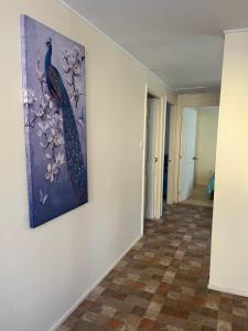 a painting of peacocks on a wall in a hallway at Cabañas Sol y Mar in Puerto Montt