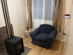 a living room with a blue chair and a television at Cabañas Sol y Mar in Puerto Montt