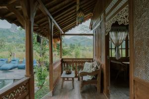 a porch of a house with a table and chairs at Green vanilla mincung 2 in Silebeng