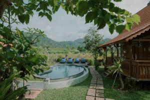 a swimming pool with blue chairs in a yard at Green vanilla mincung 2 in Silebeng