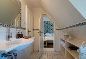 a bathroom with a sink and a bed in a room at Boutiquehotel Seiler Hof Keitum in Keitum +210 photos