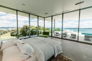 a bedroom with a large bed and large glass windows at Eagles Nest in Russell +46 photos