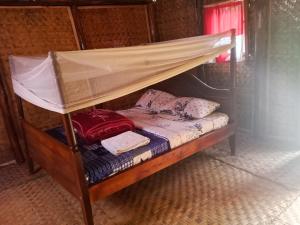 a bunk bed with a canopy in a room at Weaver Bird Hostel in Rubanda