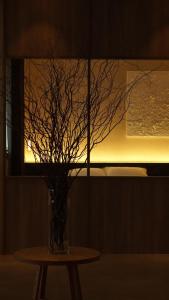 a vase with branches in it sitting on a table at 雲居月-kumoizuki- in Ginowan +67 photos