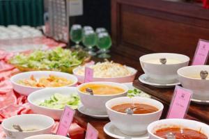 a buffet of food with bowls of soup and vegetables at EG Paradise Angkor Villa Hotel in Siem Reap +72 photos