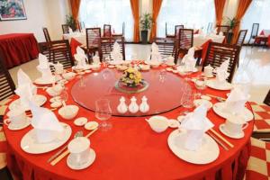 a red table with white dishes and chopsticks on it at EG Paradise Angkor Villa Hotel in Siem Reap