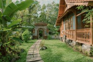 an entrance to a house with a garden and a walkway at Green vanilla mincung 2 in Silebeng