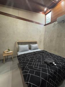 a bedroom with a bed with a cat laying on it at Pam's Cabin Batukaras in Batukaras +17 photos
