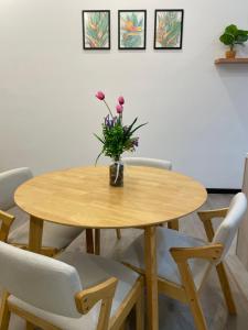 a wooden table with a vase of flowers on it at ResidenShals in Putrajaya