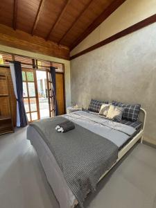 a bedroom with a large bed in a room at Pam's Cabin Batukaras in Batukaras