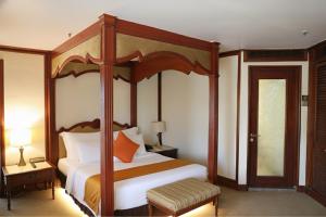 a bedroom with a large bed with a wooden canopy at Primula Beach Hotel in Kuala Terengganu +40 photos