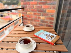 a book and a cup of coffee on a wooden table at Loft Elegante con Vista a la Ciudad in Sogamoso