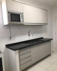 a kitchen with a sink and a microwave at Loft Gracas Inn in Recife