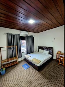 a bedroom with a bed and a wooden ceiling at Apatuxay Vientiane Hostel in Vientiane +20 photos