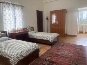 a room with two beds and a rug at Deepalaya in Guwahati