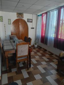 a dining room with a table and chairs and curtains at Carkey's Staycation in Siliguri