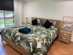 a bedroom with a bed with a blue suitcase on it at Kalani - The Heavens View House in Freshwater +33 photos