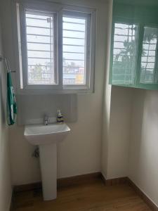 a bathroom with a sink and two windows at Deepalaya in Guwahati +4 photos