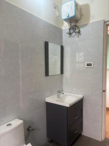 a bathroom with a sink and a toilet and a tv at Deepalaya in Guwahati
