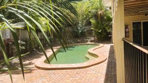 a small pool with palm trees in a yard at Kalani - The Heavens View House in Freshwater