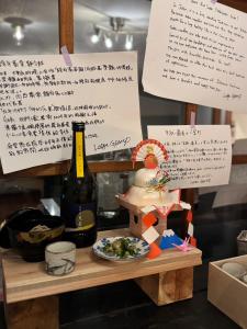 a table with a bottle of wine and a plate of food at Lodge GRAMP アルプスの見える隠れ家 in Omachi +27 photos