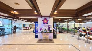 a lobby of a mall with a flower display in the middle at Primula Beach Hotel in Kuala Terengganu