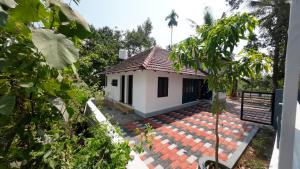 a small white house with a red roof at Haven roots in Trivandrum