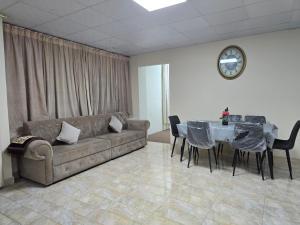a living room with a couch and a table with chairs at NMY Farm1 in Ras al Khaimah