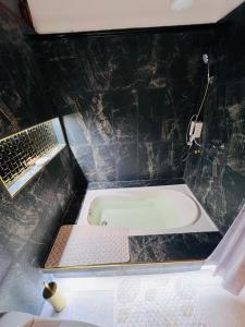 a bathroom with a bath tub in a black tiled wall at Cesar Palace Departamento in Cojimíes