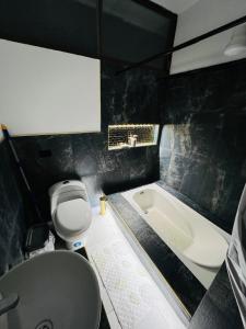 a bathroom with a toilet and a bath tub at Cesar Palace Departamento in Cojimíes