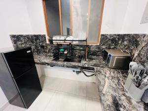 a kitchen counter with a sink and a microwave at Cesar Palace Departamento in Cojimíes +24 photos