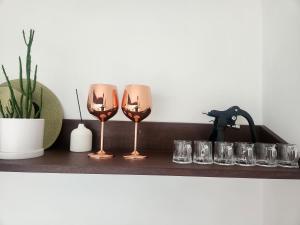 two wine glasses on a wooden shelf with a plant at Andong Hanok Stay Hue in Andong