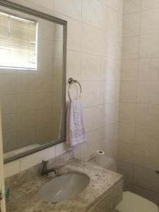 a bathroom with a sink and a mirror and a toilet at Hotel Santa Fé in Ponta Grossa +49 photos