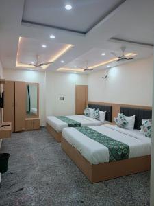 a hotel room with two beds and a mirror at HOTEL SHIVAAY near by urban Square mall and nexus celebration mall in Bedla