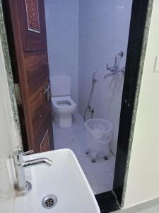 a bathroom with a toilet and a sink and a mirror at HOTEL SHIVAAY near by urban Square mall and nexus celebration mall in Bedla