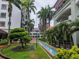 a courtyard of a building with a pool and palm trees at White House in Malacca