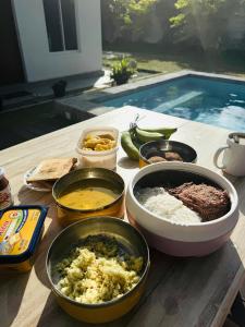 a table with bowls of food on a table next to a pool at Villa Wansha in Ratgama Hegoda