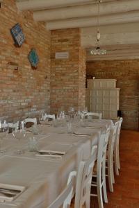 a room with a long table with white chairs at Locanda Acciuga MM in Piazzola sul Brenta