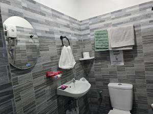 a bathroom with a sink and a toilet and a mirror at Mollucan Suite Moalboal in Moalboal +21 photos