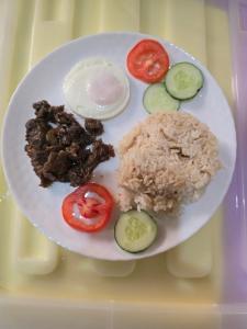 a plate of food with rice and vegetables on a tray at Mollucan Suite Moalboal in Moalboal