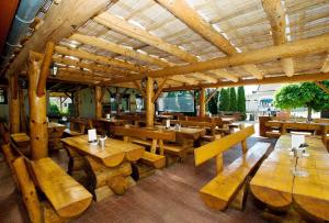 a restaurant with wooden tables and wooden benches at Villa Marcus - rodinný relax 200 m od Penzionu Kometa, u jezera s grilem a sdílenou kuchyní in Pasohlávky