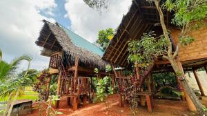 a house with a thatched roof at Sigiri Aliya Tree house in Sigiriya