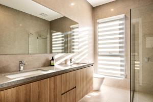 a bathroom with a sink and a toilet and a mirror at Shining House Villa B in Tanunda