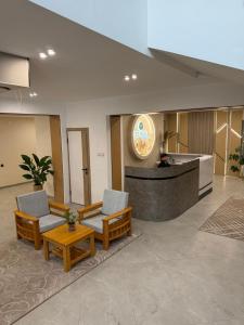 a lobby with two chairs and a reception desk at TES Hotel in Osh