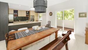 a kitchen and dining room with a wooden table at Mackaren's Lodge - Chic in Macmasters Beach