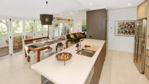 a kitchen and living room with white countertops at Mackaren's Lodge - Chic in Macmasters Beach