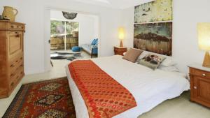 a bedroom with a large white bed and a rug at Mackaren's Lodge - Chic in Macmasters Beach